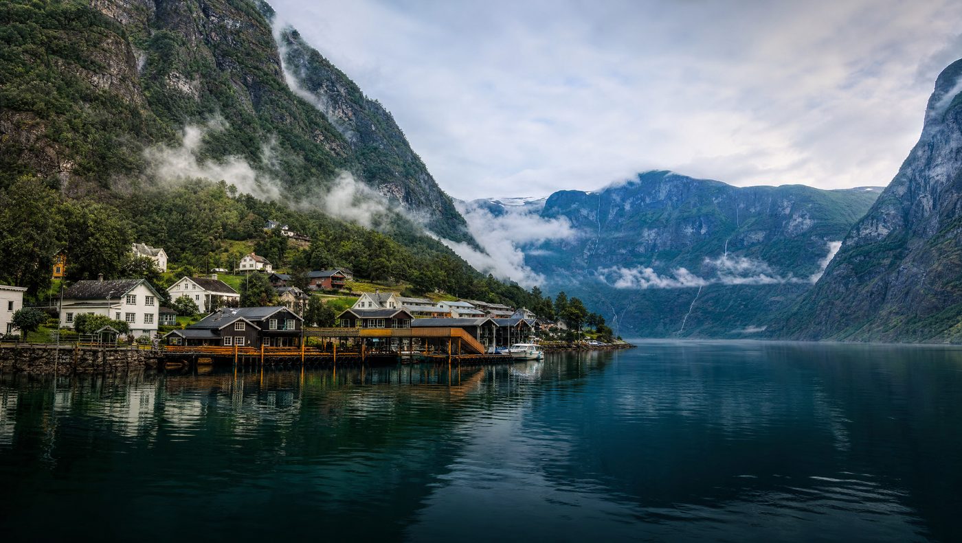 Foggy fjord village at Flåm with wooden houses on the dock
