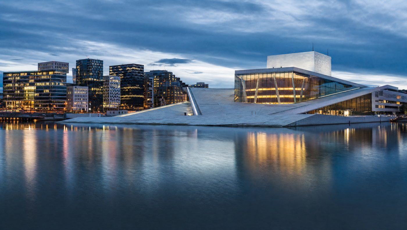 Oslo Opera House and skyline at dusk, reflected in the fjord